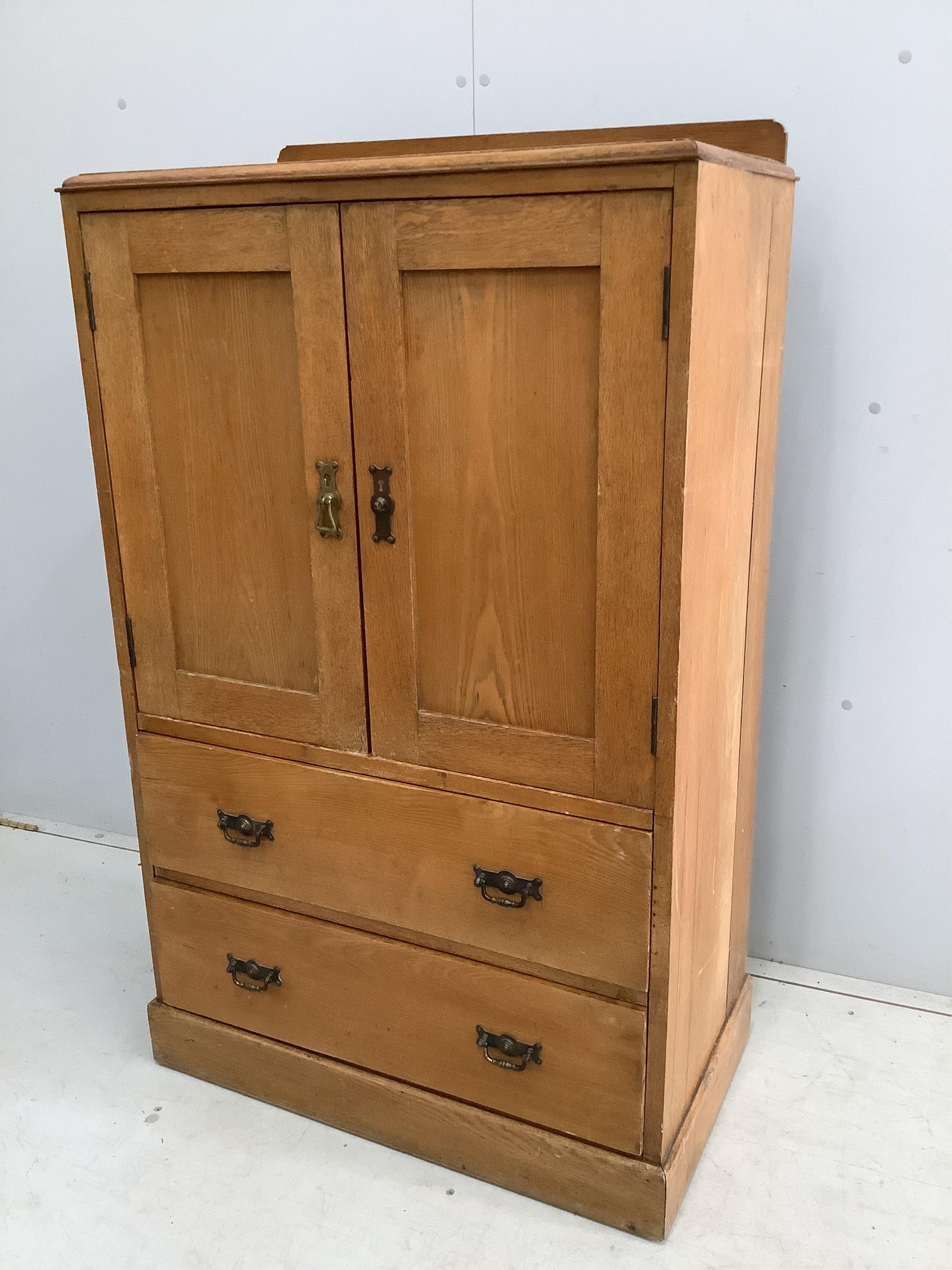 An early 20th century small oak press cupboard, width 75cm, depth 42cm, height 124cm